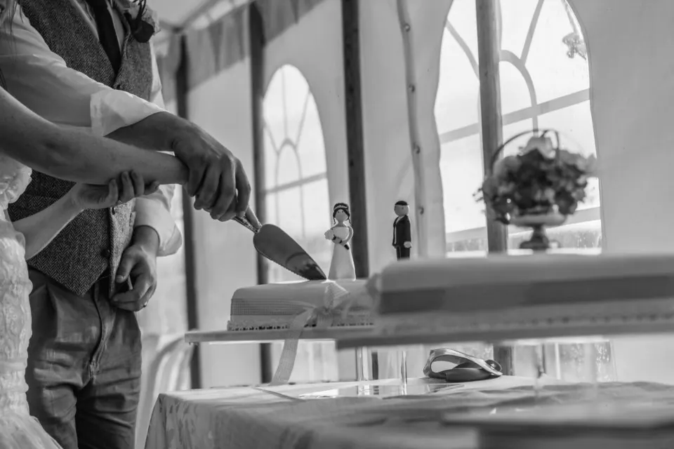 Novios cortando la tarta en blanco y negro en una boda en Málaga