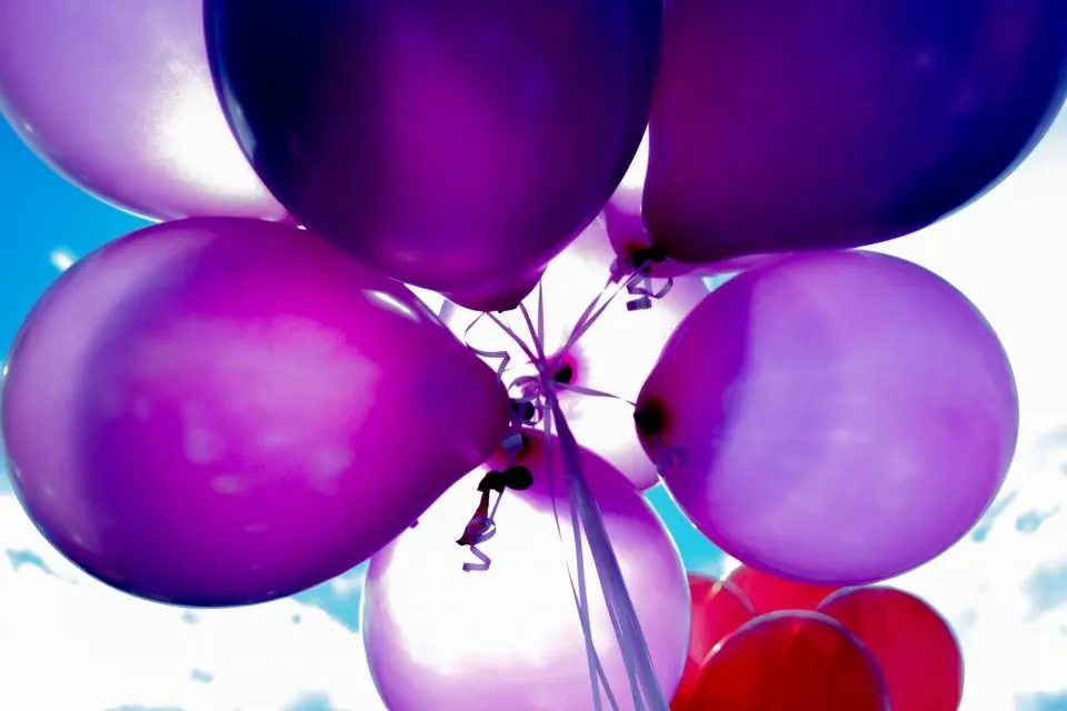 Globos morados soltados al cielo durante la animación infantil de una comunión en Málaga