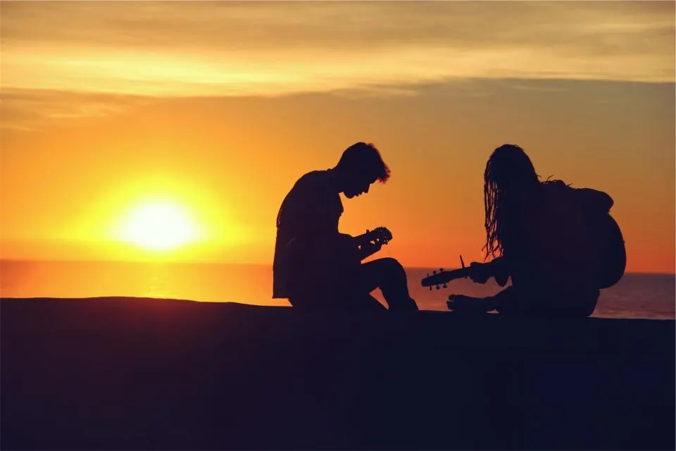 Músicos con guitarra al atardecer junto al mar en una boda de destino en Málaga
