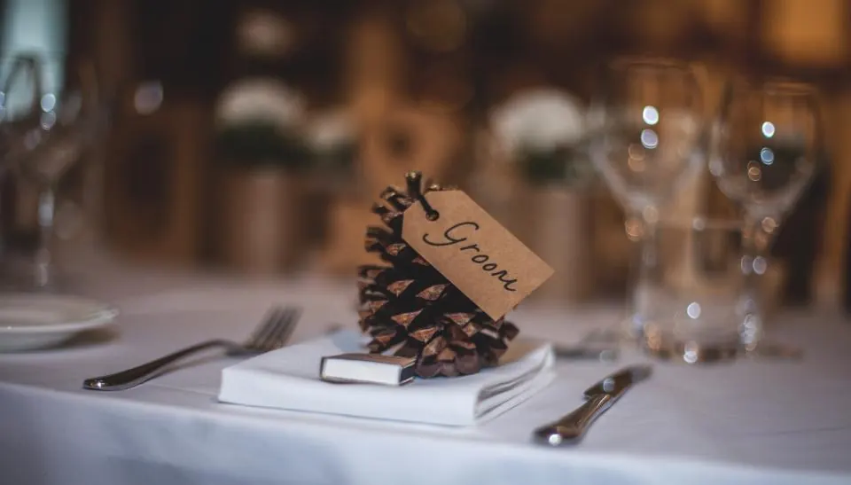 Mesa de boda en Málaga con piña y nombre del invitado sobre mantel blanco