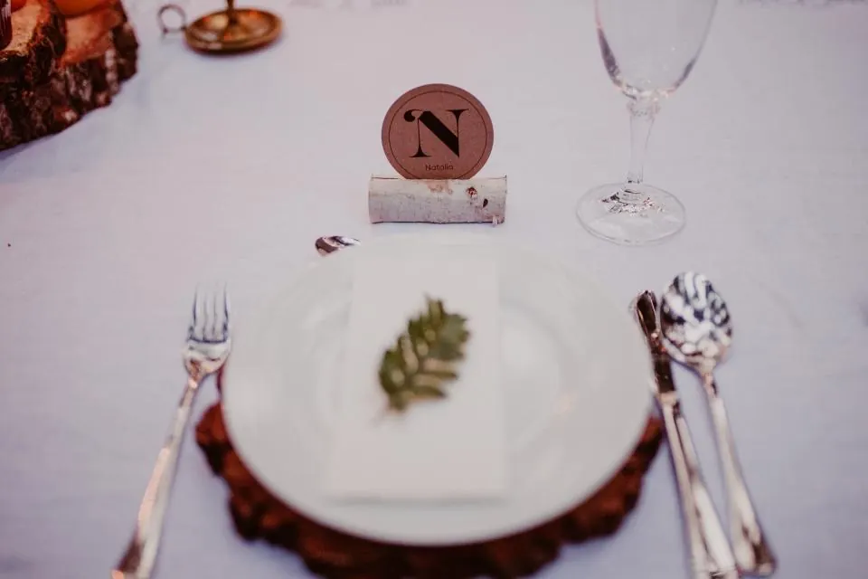 Plato y cubiertos preparados junto a una estación de espetos en un catering de boda en la Costa del Sol
